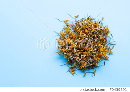 Dried marigold flower petals on blue background. 70439591