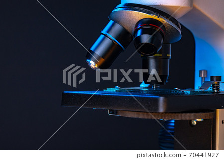 Microscope with lenses close up against dark background 70441927