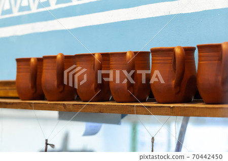 Clay pots on a wooden shelf close up Clay pots on a wooden shelf close up 70442450