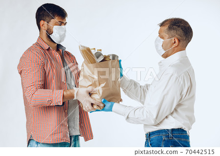 Delivery man in face mask and gloves. Food delivery, online shopping concept while coronavirus pandemia 70442515