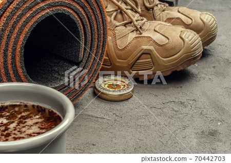 Hiking boots with travel accessories on grunge background 70442703