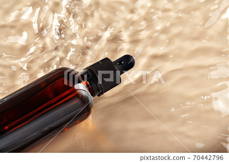 Cosmetic bottle with pipette in wavy water Cosmetic bottle with pipette in wavy water 70442796