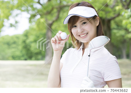 A woman with a golf ball 70443682