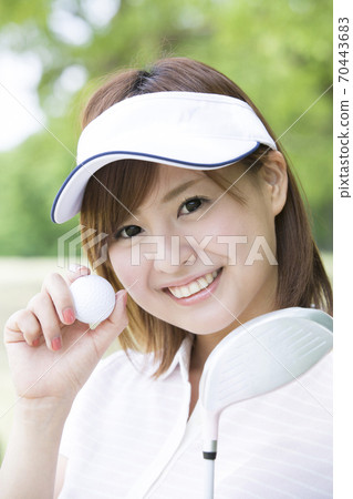 A woman with a golf ball 70443683