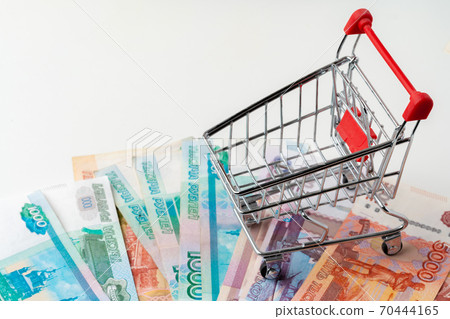 Toy shopping cart with Russian rubles money. Living wage and purchasing power concept 70444165