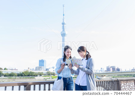 Women traveling with a guidebook for sightseeing 70444467