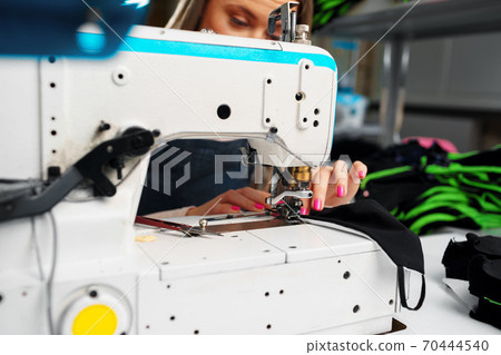 Close up of a seamstress with a sewing machine 70444540