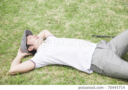 一個男人躺在草坪上 70445714