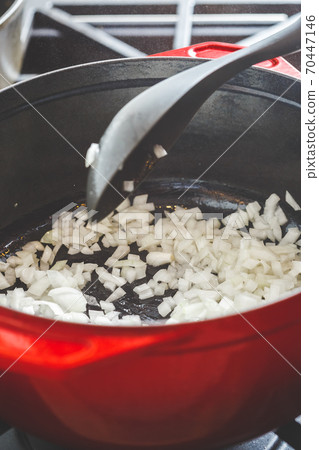 Cooking chopped white onion in cast dutch oven Cooking chopped white onion in cast dutch oven 70447146