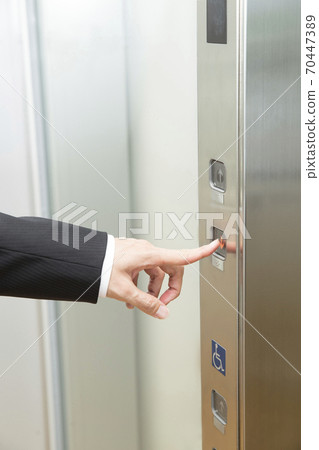 At hand pressing the elevator button 70447389
