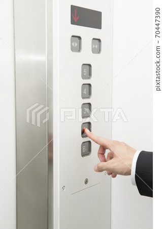 At hand pressing the elevator button 70447390
