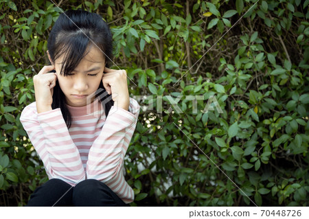 Stressed asian child girl covering ears with fingers because of loud noise,fear of noise,feel panic, anxiety female people having mental disorder, health problem, Misophonia, Acousticophobia concept 70448726