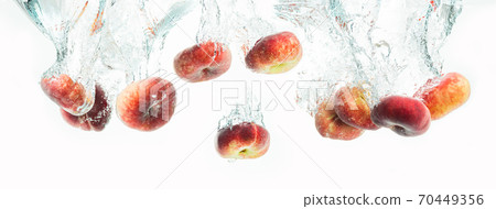 Bunch of doughnut peaches isolated on white background, splashing into water. 70449356