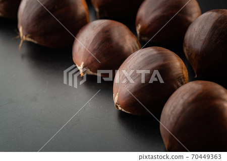 Rows of chestnuts isolated on black background 70449363