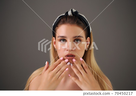 Attractive young girl touching her lips. Photo of blonde girl with perfect skin on grey background. Beauty Skin care concept Attractive young girl touching her lips. Photo of blonde girl with perfect skin on grey background. Beauty Skin care concept 70450217