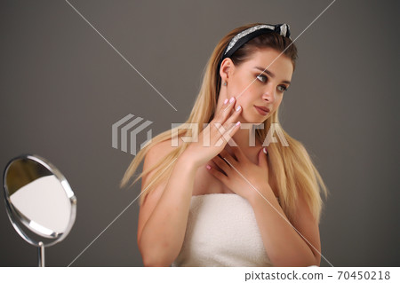 Beautiful woman with long hair natural fashion make up cosmetic spa beauty concept of woman sitting at the table near the mirror 70450218