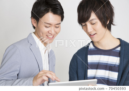 一個人看著一台平板電腦 70450393