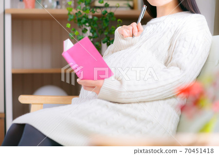 Pregnant woman thinking about schedule book Pregnant woman thinking about schedule book 70451418