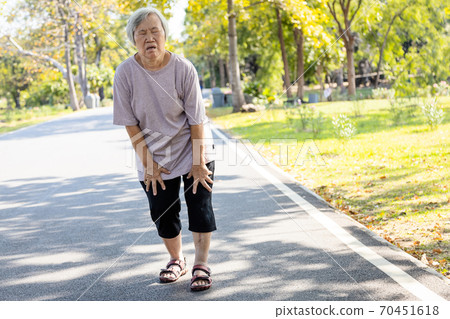 Asian senior woman is extremely tired while walking at park, body is weak feeling tired easily due to lack of energy and don’t exercise very often, exhausted elderly people have the symptoms fatigue 70451618
