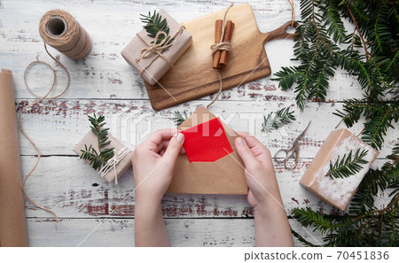Girl's hands hold an envelope with red paper on white background  70451836