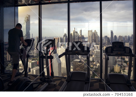 A man on fitness equipment in fitness club 70453168