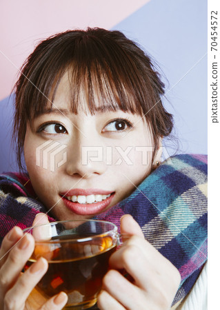 一個女人喝一杯熱飲料 70454572