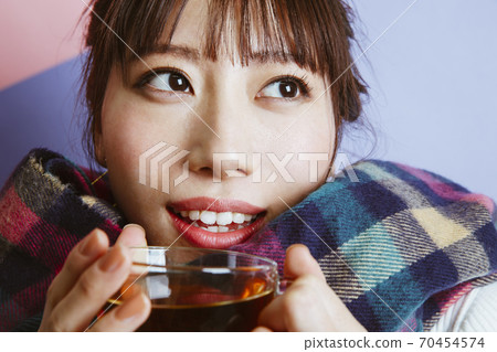 一個女人喝一杯熱飲料 70454574