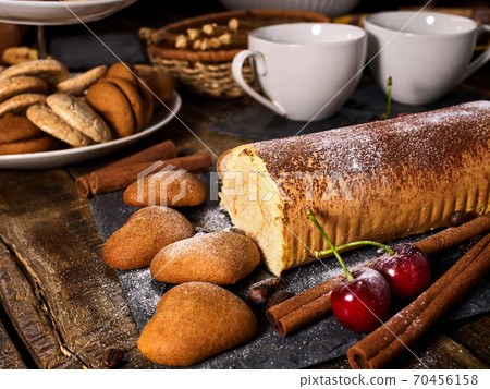 Oatmeal cookies ,rolled cake on tier cake stand with cherry 70456158