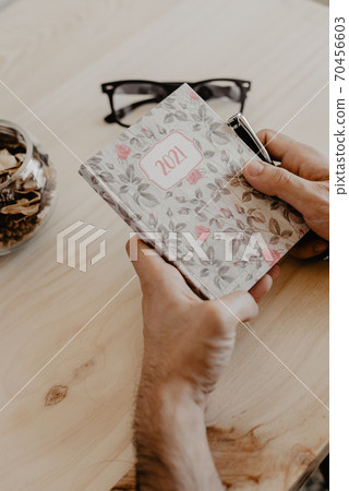 a man sitting at a desk plans the year 2021 70456603