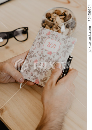 a man sitting at a desk plans the year 2021 a man sitting at a desk plans the year 2021 70456604