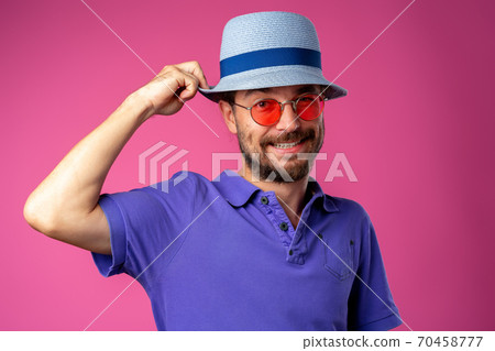 Funny bearded smiley man wearing beach hat and sunglasses Funny bearded smiley man wearing beach hat and sunglasses 70458777