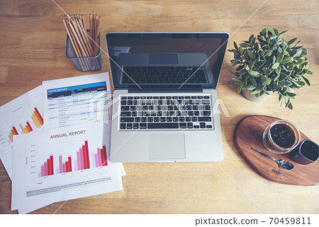 Office laptop business financial document chart and graph on wooden table with coffee cup Office laptop business financial document chart and graph on wooden table with coffee cup 70459811
