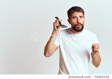 man with cooking shovel and white t-shirt close-up cropped view emotion gesturing with hand man with cooking shovel and white t-shirt close-up cropped view emotion gesturing with hand 70462016