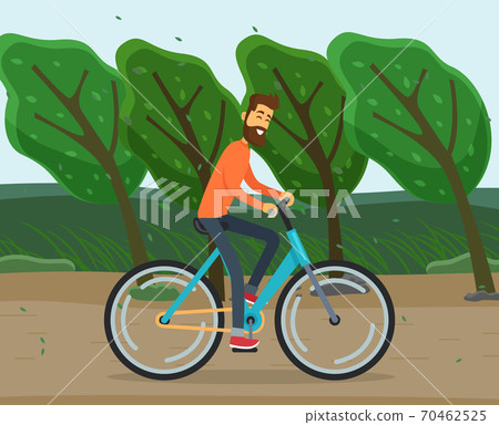 Cyclist rides bicycle on country road. Windy weather tilts trees, picks leaves. Active leisure 70462525