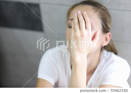 Woman in depression sits with closed eyes 70462580