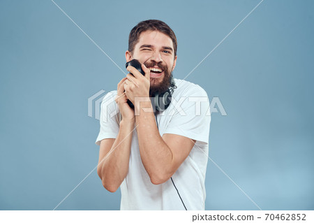 A man with a controller in his hands headphones games hobby leisure technology lifestyle blue background A man with a controller in his hands headphones games hobby leisure technology lifestyle blue background 70462852
