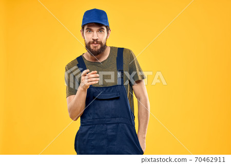 man in work uniform rendering service forklift work lifestyle yellow background 70462911