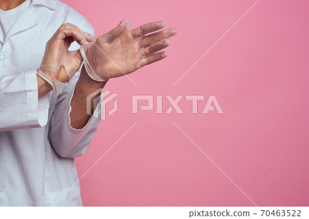 medical gown hands in transparent gloves pink background cropped view 70463522