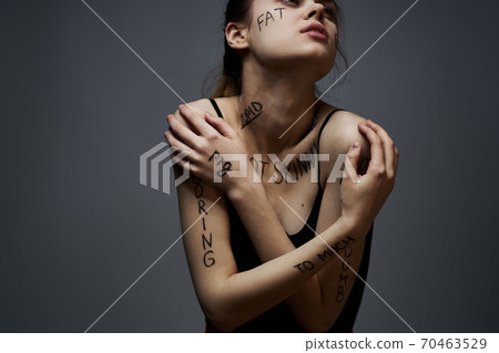 Emotional woman with inscriptions on her body gestures with hands lifestyle frustration stress gray background Emotional woman with inscriptions on her body gestures with hands lifestyle frustration stress gray background 70463529