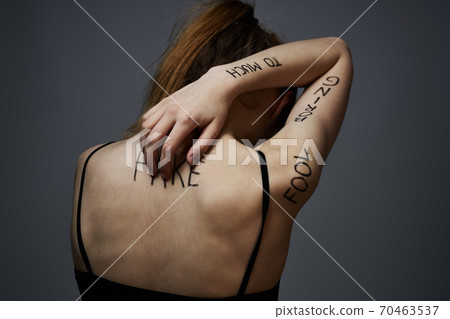 Woman with inscriptions on the body frustration and dissatisfaction emotions lifestyle gray background Woman with inscriptions on the body frustration and dissatisfaction emotions lifestyle gray background 70463537