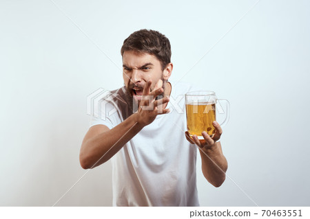 man with a mug of beer in his hands and a white t-shirt light background mustache beard emotions model man with a mug of beer in his hands and a white t-shirt light background mustache beard emotions model 70463551