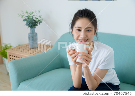 Beautiful woman enjoying coffee at home Beautiful woman enjoying coffee at home 70467845