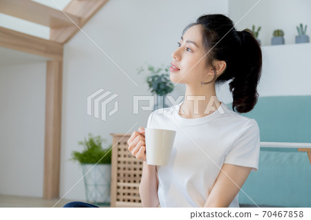 Beautiful woman enjoying coffee at home Beautiful woman enjoying coffee at home 70467858