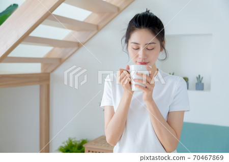 Beautiful woman enjoying coffee at home Beautiful woman enjoying coffee at home 70467869