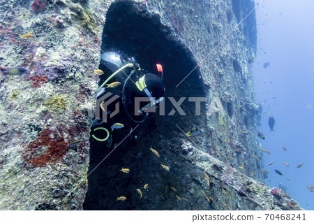 Diver looking out of the hatch in the tower of the sunken ship at the bottom of the Indian ocean 70468241