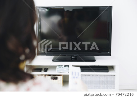 A woman watching TV 70472216