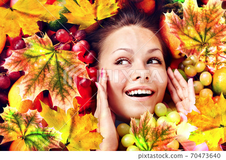 Autumn leaves background with face and hands woman 70473640