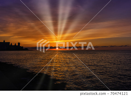 Sunset over Malecon and Atlantic Ocean with visible sun rays - Havana, Cuba  70474121