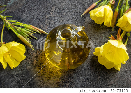 A bottle of evening primrose oil with blooming evening primrose plant 70475103