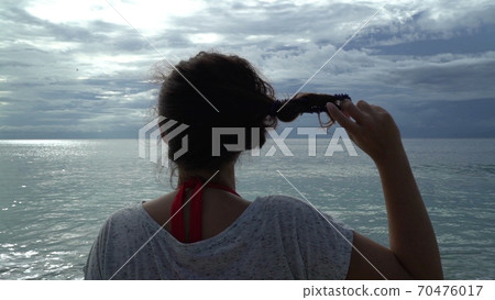 woman on beach sunset letting her hair down release from pin, freedom holidays concept woman on beach sunset letting her hair down release from pin, freedom holidays concept 70476017